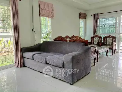 Spacious living room with elegant furniture and large windows offering natural light.