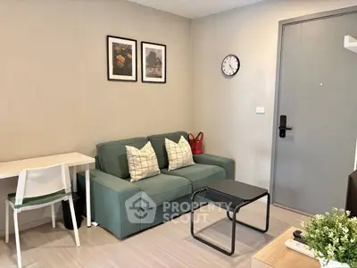 Cozy living room with green sofa, modern decor, and wall art in a stylish apartment.