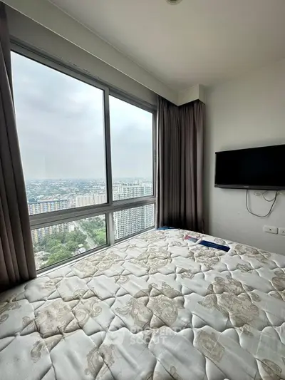 High-rise bedroom with panoramic city view and wall-mounted TV