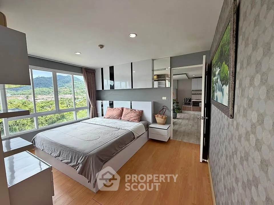 Spacious bedroom with scenic view and modern decor in a high-rise apartment.