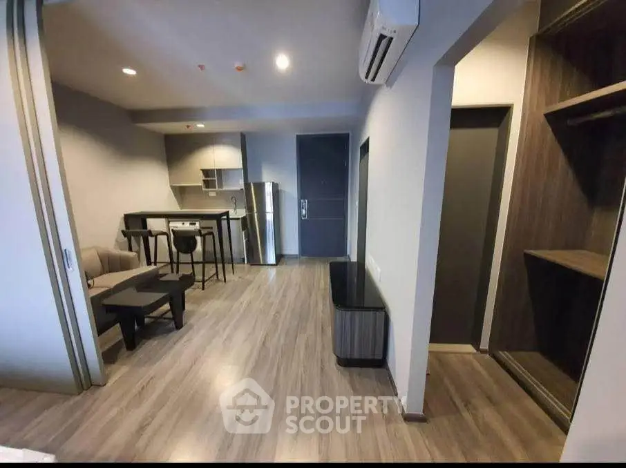 Modern open-plan living room with sleek kitchen and stylish flooring in a contemporary apartment.