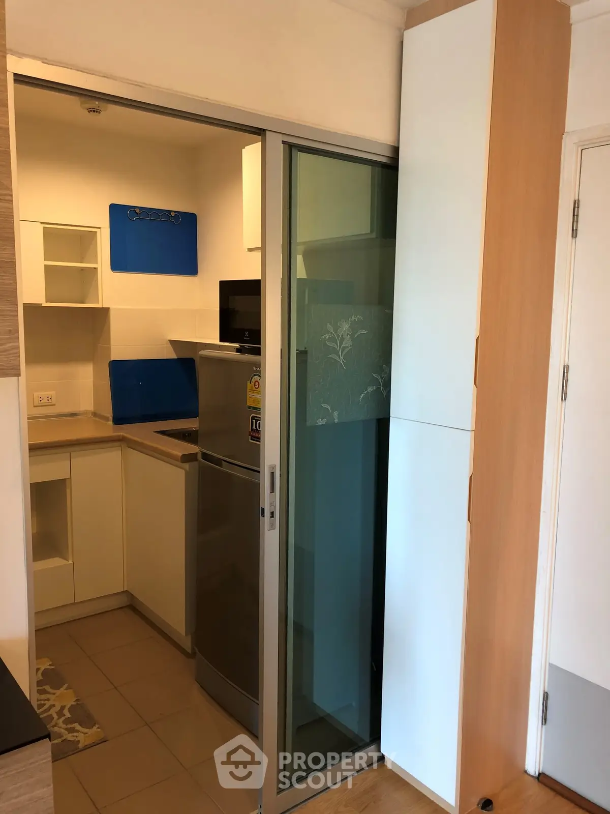 Compact modern kitchen with sliding glass door and sleek appliances