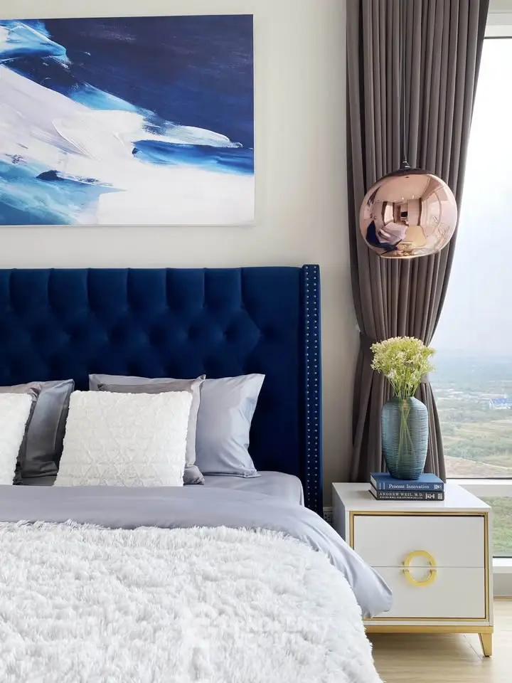 Luxurious bedroom with plush blue headboard and modern decor