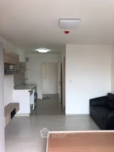 Modern apartment interior with open layout, featuring a compact kitchen and cozy living area.
