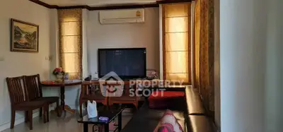 Cozy living room with modern furniture and large TV, perfect for relaxation and entertainment.