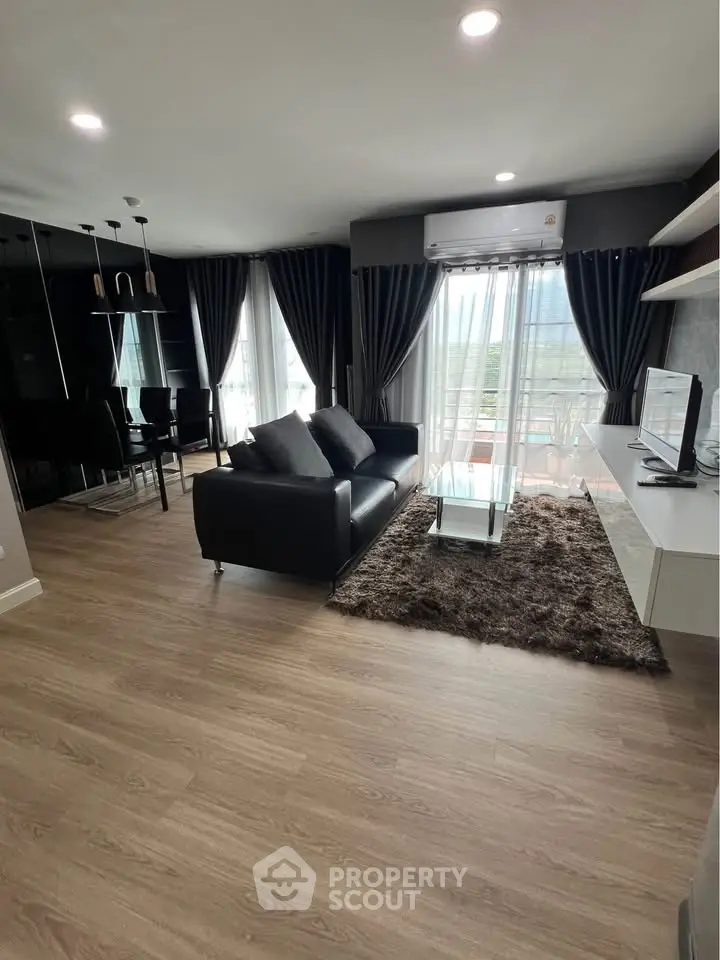 Modern living room with sleek furniture and large windows offering natural light.