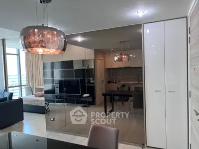 Modern open-plan living room with sleek kitchen and stylish lighting in a contemporary apartment.