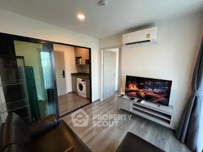 Modern living room with sleek furniture and integrated kitchen appliances in a stylish apartment.