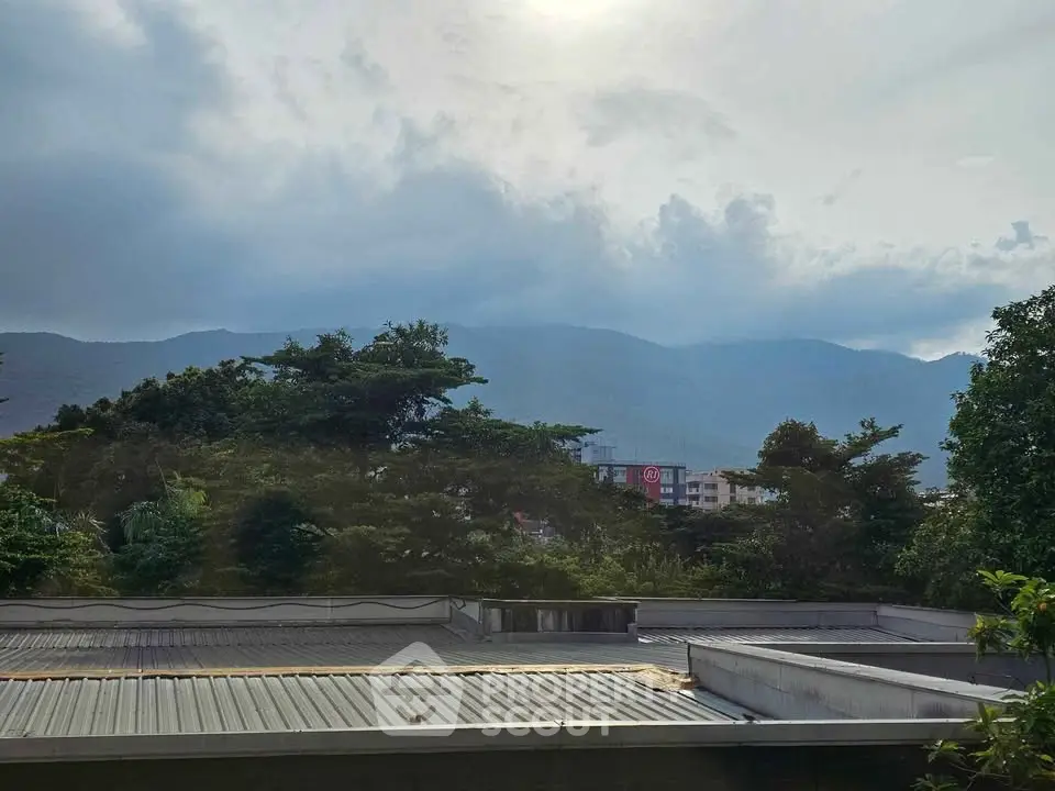Scenic view from a rooftop overlooking lush greenery and distant mountains, perfect for nature lovers.