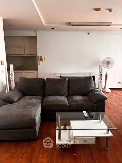 Modern living room with plush gray sofa, sleek coffee table, and stylish wooden flooring.