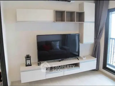 Modern living room with sleek TV unit and balcony view