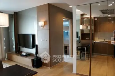 Modern living room with sleek design and open kitchen layout, featuring wooden flooring and stylish decor.