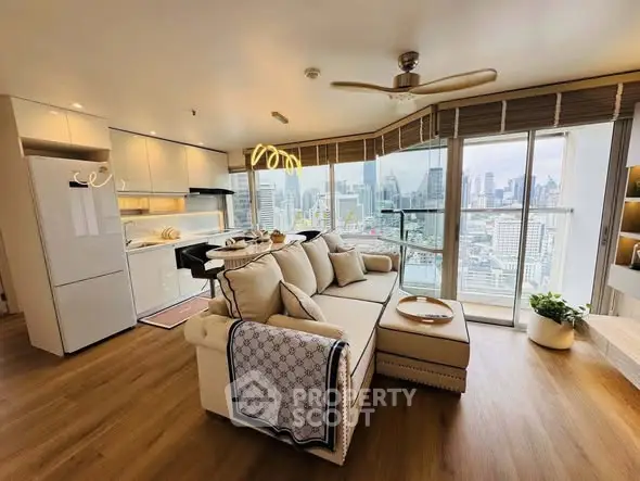 Modern living room with city view, open kitchen, and stylish decor in high-rise apartment.