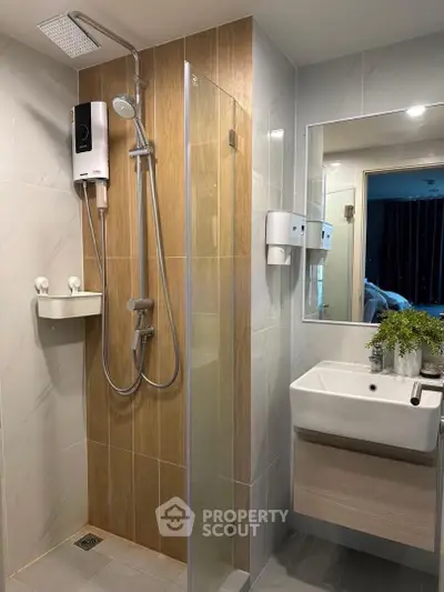 Modern bathroom with sleek shower and stylish sink in contemporary apartment.