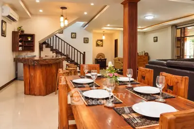 Luxurious open-plan living and dining area with elegant wooden furniture and modern lighting.
