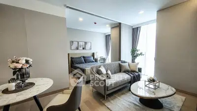 Luxurious open-plan living room with elegant decor and cozy bedroom area