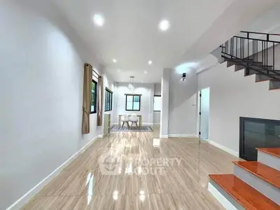 Spacious modern living area with elegant staircase and dining space