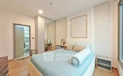 Modern bedroom with stylish decor and large window offering natural light