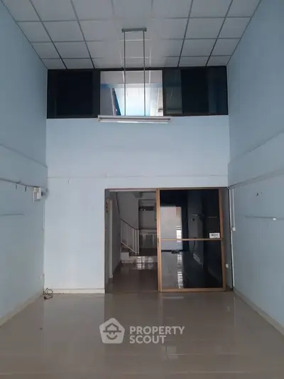 Spacious commercial property with high ceilings and modern glass partition, ideal for business setup.