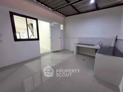 Spacious modern kitchen with sleek countertops and ample natural light.