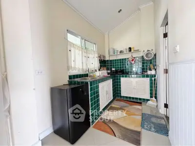 Charming kitchen with green tiles and compact fridge in cozy home