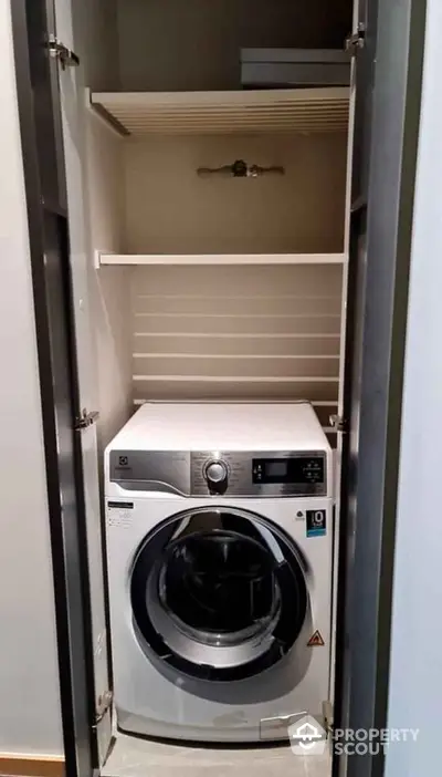 Compact laundry space with modern washing machine in sleek cabinet