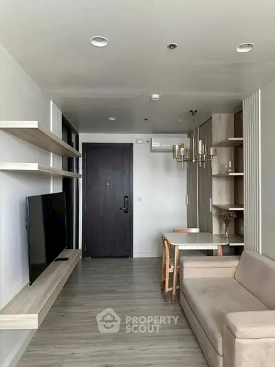Modern living room with sleek furniture and wall-mounted TV in a stylish apartment.