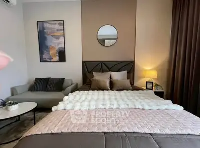 Stylish bedroom with modern decor, cozy seating area, and elegant lighting.