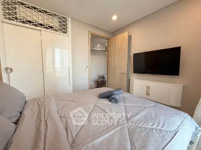 Modern bedroom with stylish decor and wall-mounted TV in a cozy apartment.