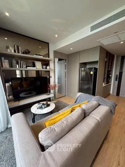 Modern living room with stylish decor and open layout, featuring a cozy sofa and sleek shelving.