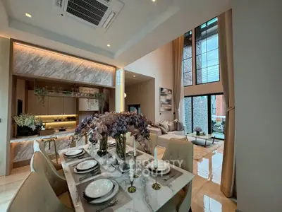 Luxurious open-plan living and dining area with high ceilings and elegant decor