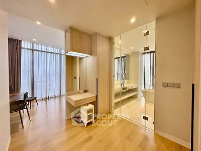Spacious modern living area with glass partition and wooden flooring