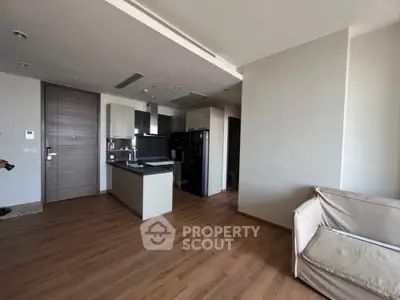Modern open-plan living room with sleek kitchen and wooden flooring