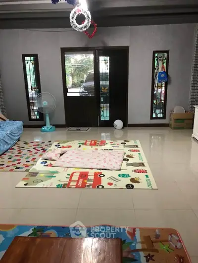 Spacious living room with playful decor and large windows for natural light.