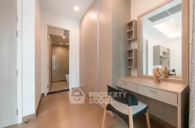 Elegant bedroom with wooden wardrobe and dressing table, featuring modern design and ample storage space.