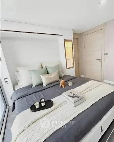 Modern bedroom with stylish decor and cozy bedding in a contemporary apartment.