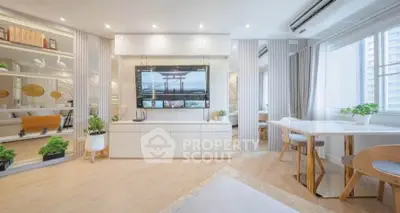 Modern living room with sleek design, large TV, and natural light from big windows, perfect for urban living.