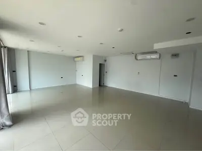 Spacious unfurnished room with tiled flooring and air conditioning, ideal for customization.