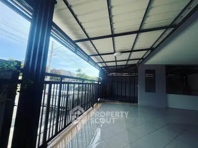 Spacious covered balcony with modern railing and tiled flooring, perfect for outdoor relaxation.