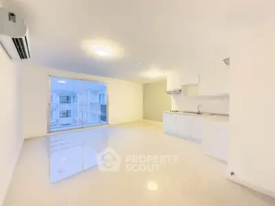 Spacious modern living room with open kitchen and large window view