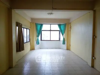 Spacious empty room with large windows and tiled floor, ideal for customization.