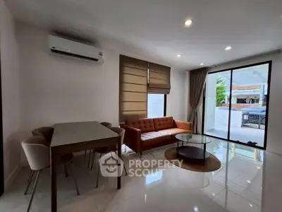 Modern living room with sleek furniture and large windows for natural light.