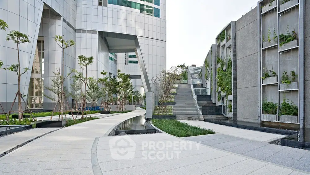Modern architectural exterior with landscaped pathways and green walls in urban setting.