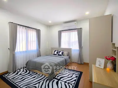 Spacious bedroom with modern decor and natural light, featuring a cozy bed and stylish furnishings.
