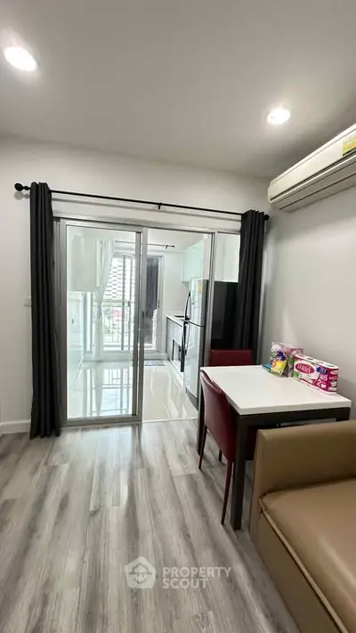Modern apartment interior with open layout, featuring a cozy dining area and sleek kitchen design.
