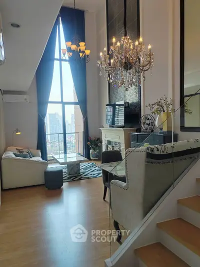 Luxurious living room with high ceilings, chandelier, and city view from large windows.