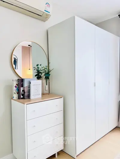 Modern bedroom with sleek white wardrobe and stylish dresser with mirror