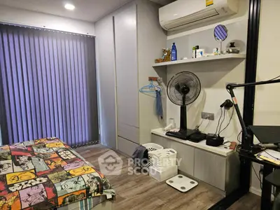 Cozy bedroom with modern decor and air conditioning, featuring a stylish comic-themed bedspread and ample storage space.