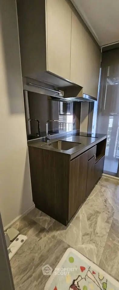 Modern kitchen with sleek cabinetry and large window for natural light