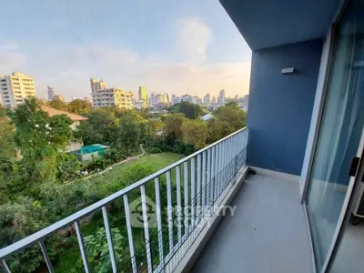 Spacious balcony with stunning city view and lush greenery